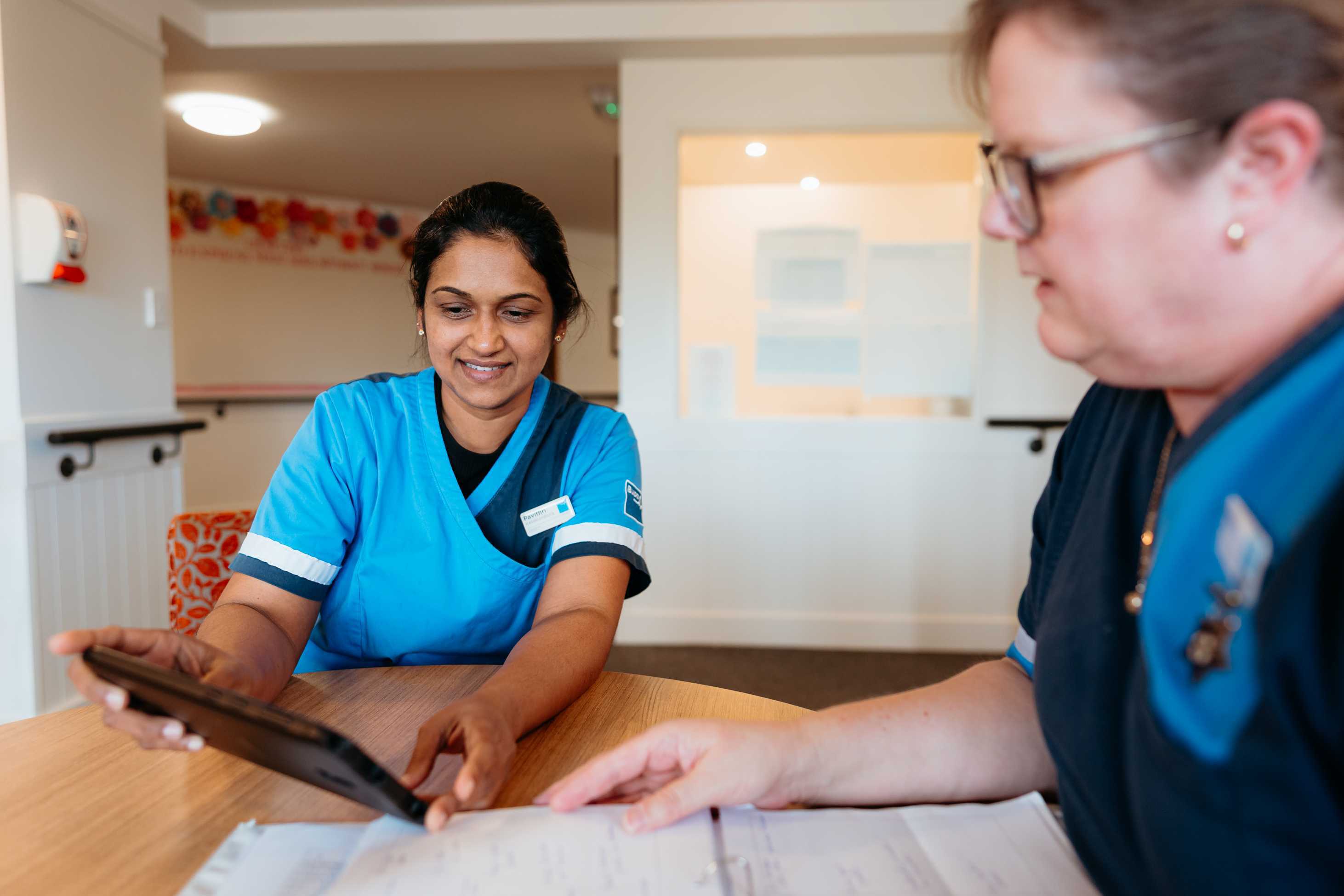 Care Home Manager with nurse reviewing AI