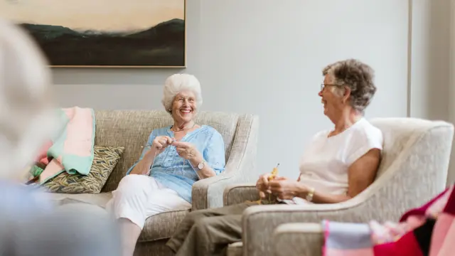Friend knitting in retirement village