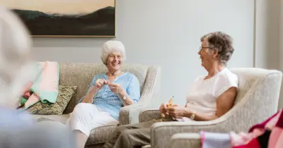 Friend knitting in retirement village