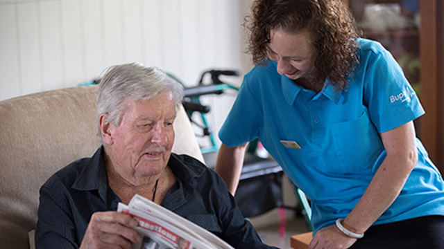 Care home reading newspaper