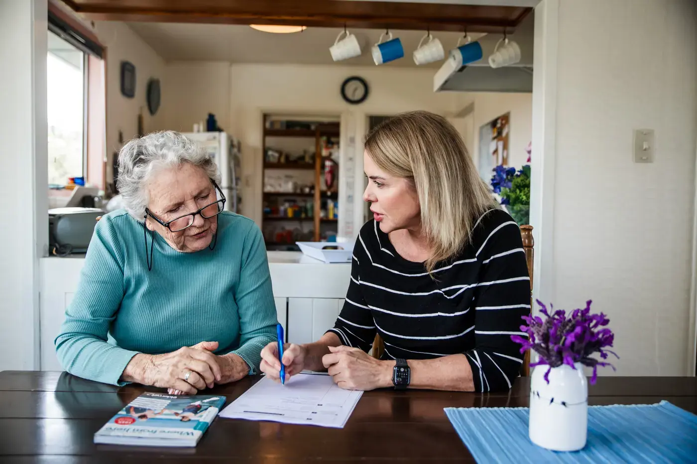 An assessor meeting with an elderly person and family member at home