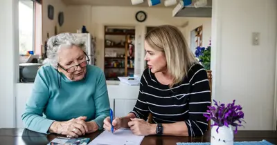 An assessor meeting with an elderly person and family member at home