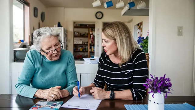 An assessor meeting with an elderly person and family member at home