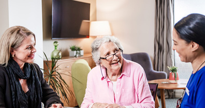 Mother and daughter  signing an admission agreement into a care home